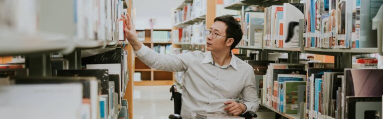 Man in wheelchair browses books in library